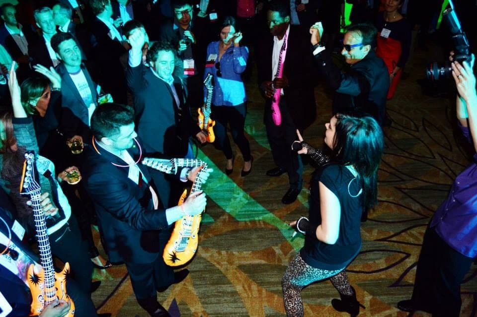 The band's guitarist playing in the middle of a dancing crowd