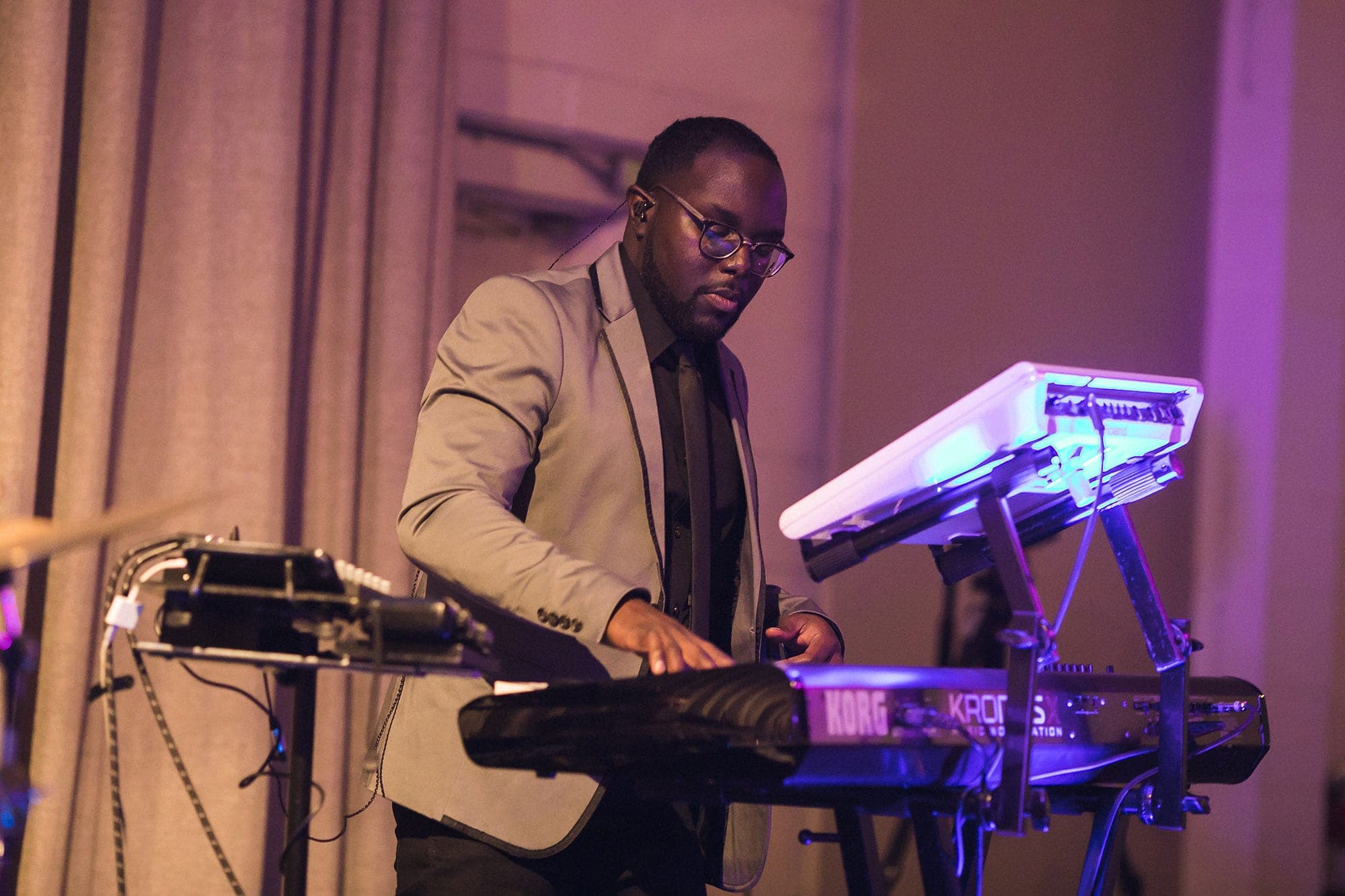 The band's keyboard player on stage under purple light